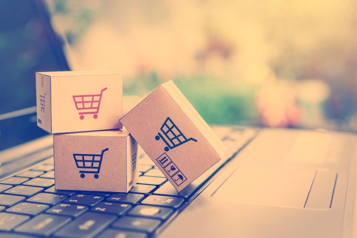 Cardboard boxes with a shopping cart logo on a laptop keyboard.